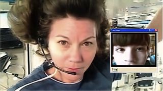a female astronaut on a webcam call with a young kid