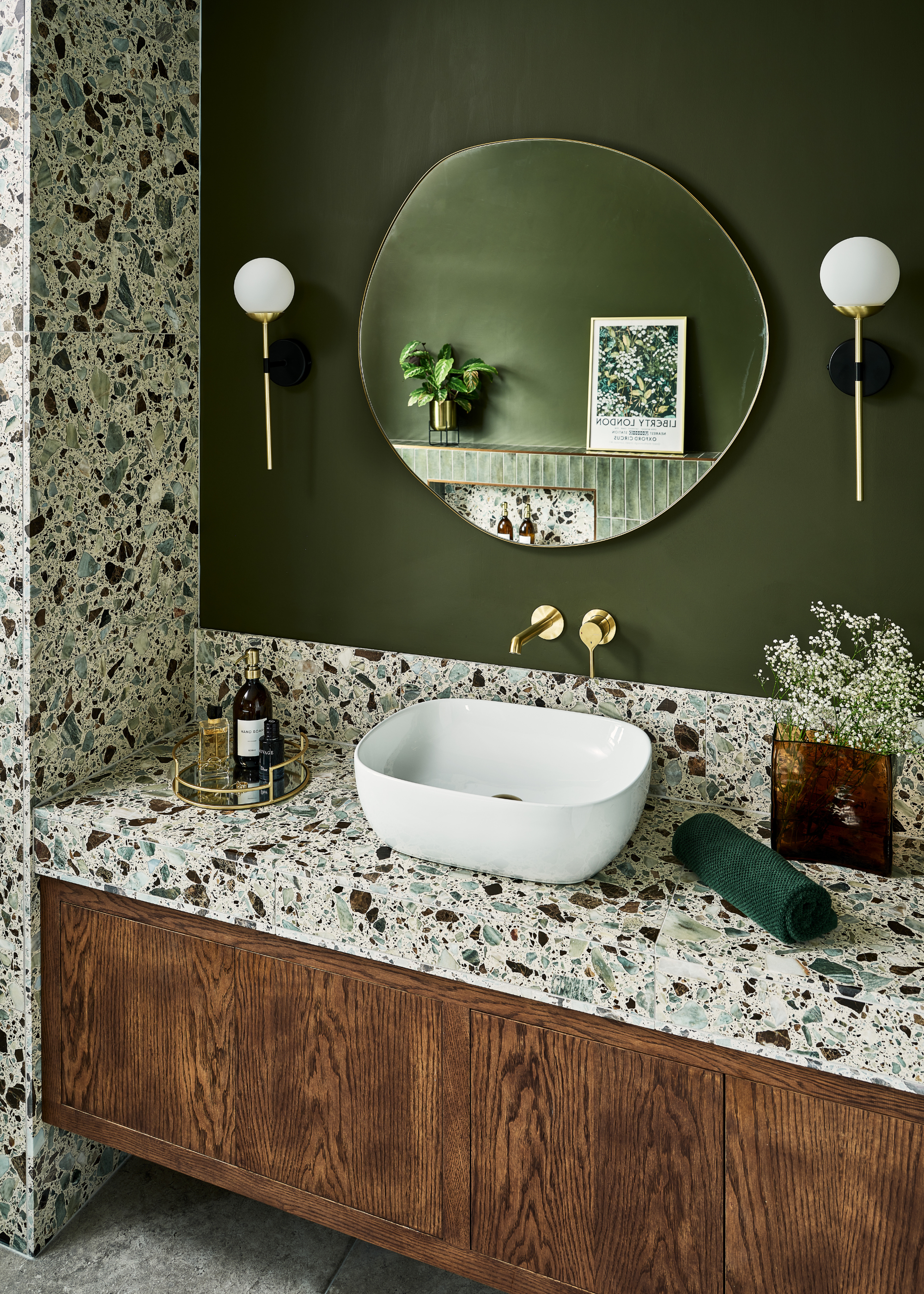 cool terrazzo bathroom with green wall and wooden cabinets