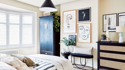 beige bedroom with artwork on the wall and a black wardrobe with large window