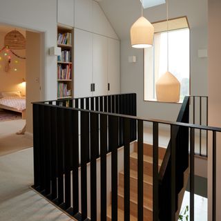 Staircase of house with black railing and small window light