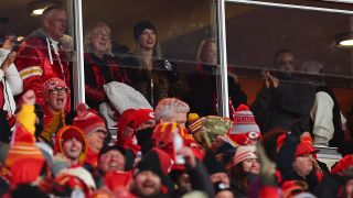 Taylor Swift next to Donna Kelce at a 2025 Kansas City Chiefs game in a box with glass windows.