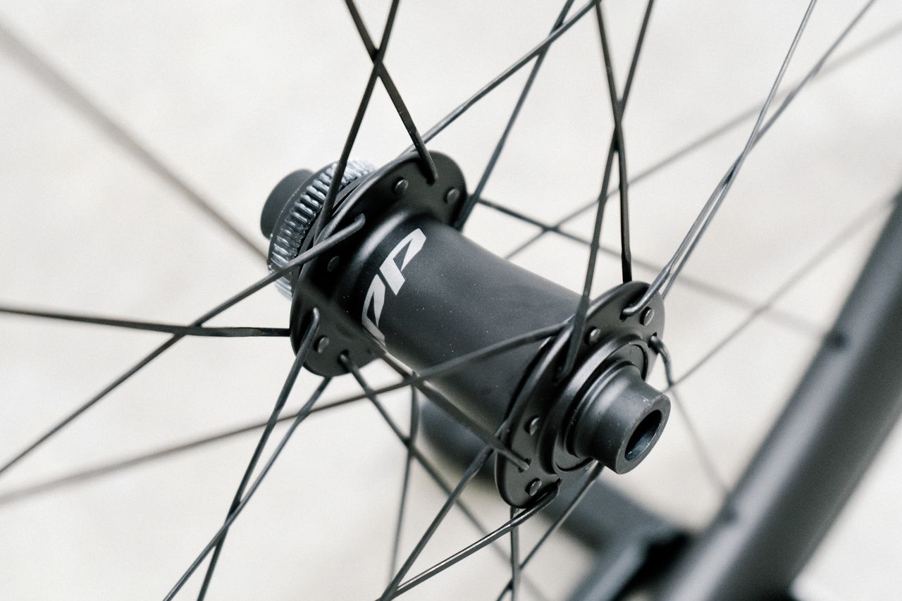 An aero road wheel stands against a white wall