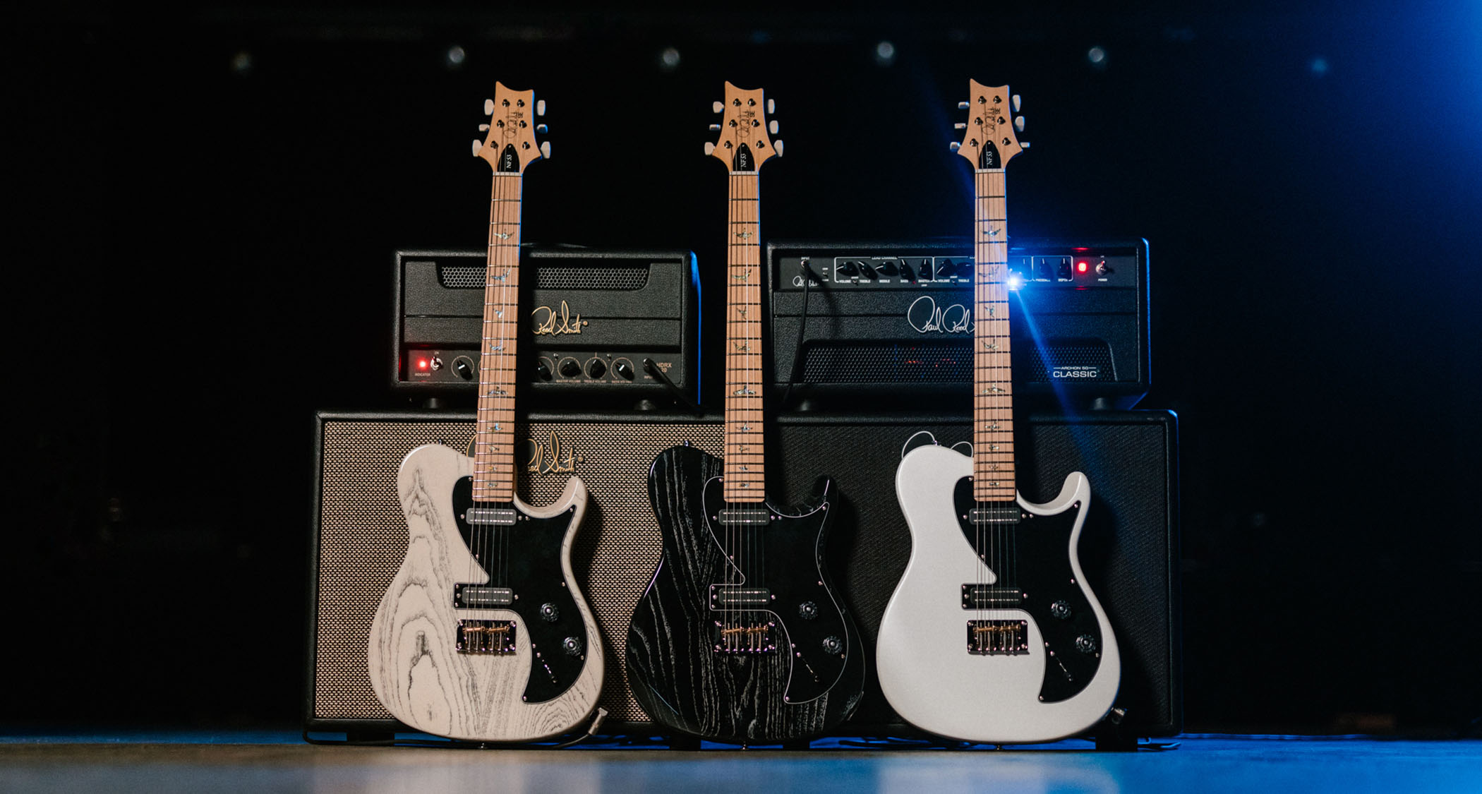 PRS SE NF 53: the super-versatile bolt-on electric gets a long-awaited SE release, and here all three finish options – White Dog Hair, Black Dog Hair and Pearl White – are photographed in front of a pair of PRS half-stacks.