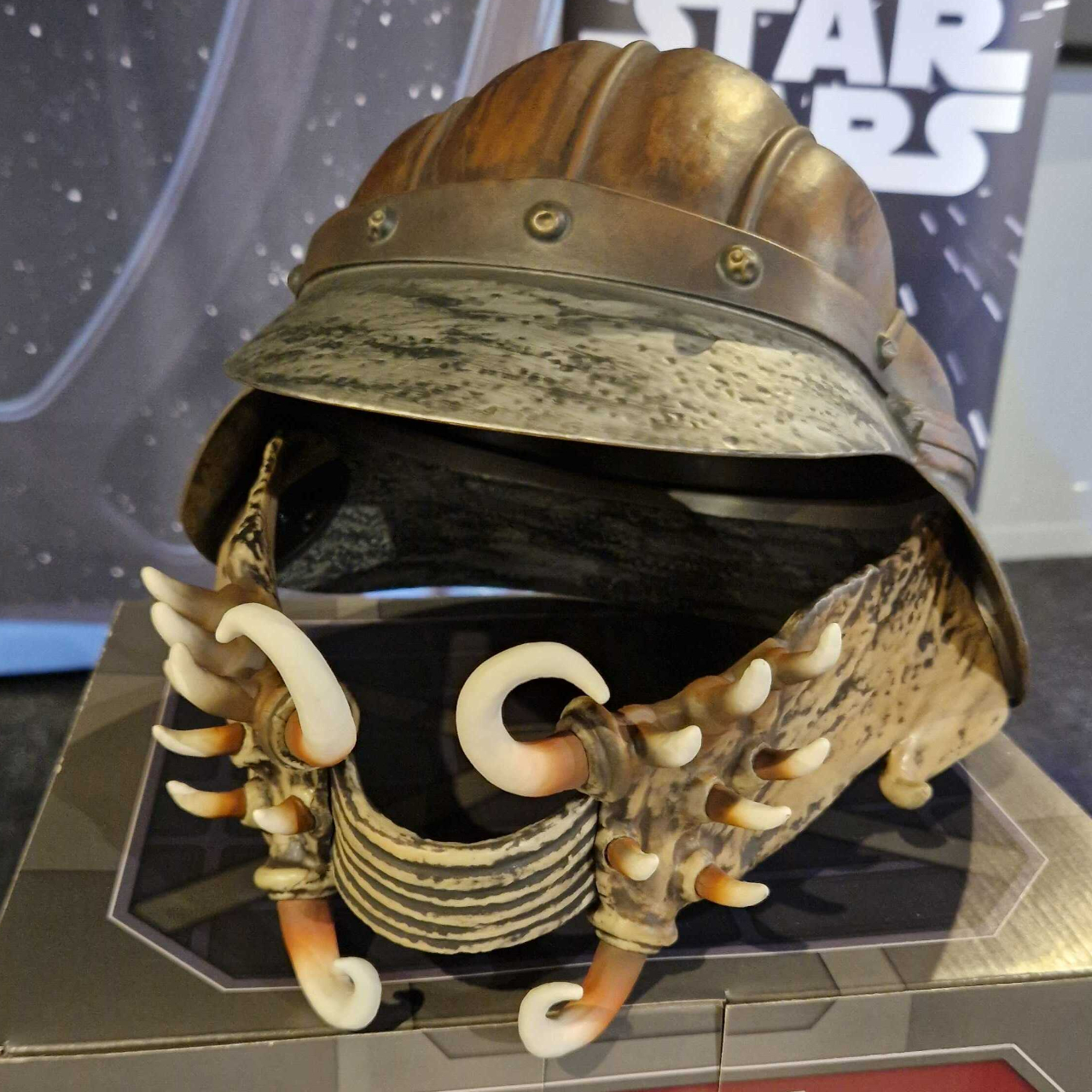 The Lando Calrissian Skiff Guard Helmet sat on a box, with the Star Wars logo visible in the background