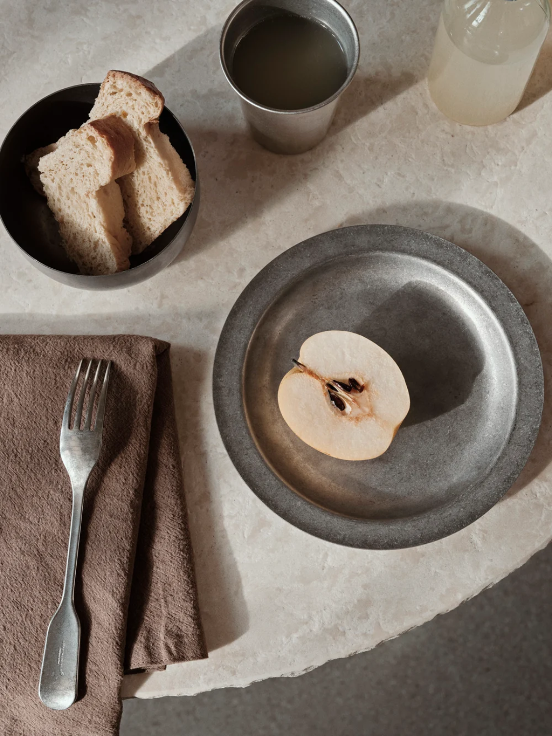 A textured tumbled cup, bowl, and plate from ferm Living