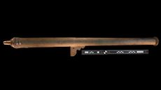 a bronze cannon against a black background
