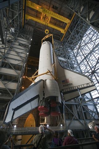 In the Vehicle Assembly Building at NASA's Kennedy Space Center in Florida, shuttle Atlantis is lifted by an overhead crane and moved into a high bay where it will be attached to its external fuel tank and solid rocket boosters which are already on the