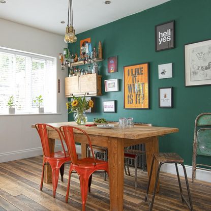 dark grey wall with wooden flooring and wooden dining table with flower on glass jar