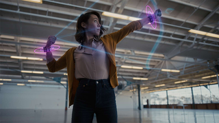 Woman wearing Meta's neural wrist bands to interact with an augmented reality interface, in this instance shooting an AR bow and arrow.