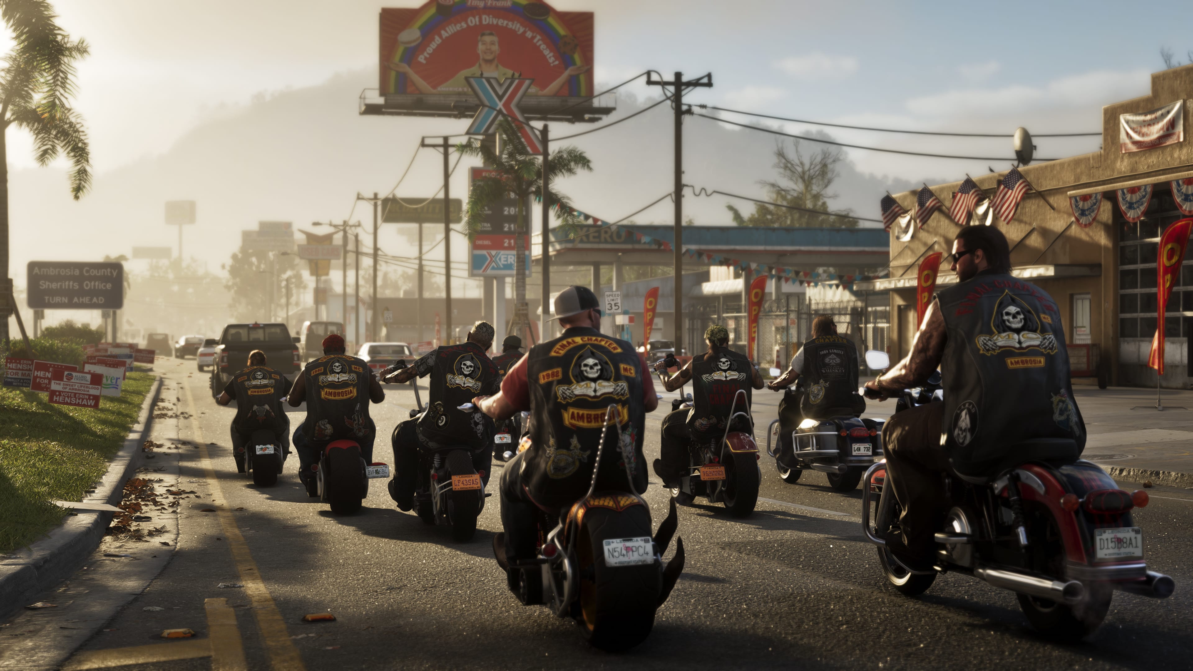 A pack of motorcyclists wearing leather vests with skull patches ride down a sunlit road in a rural town.