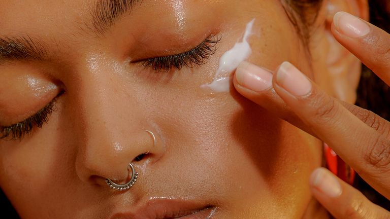 A woman putting on one of the Best moisturizers for dry skin