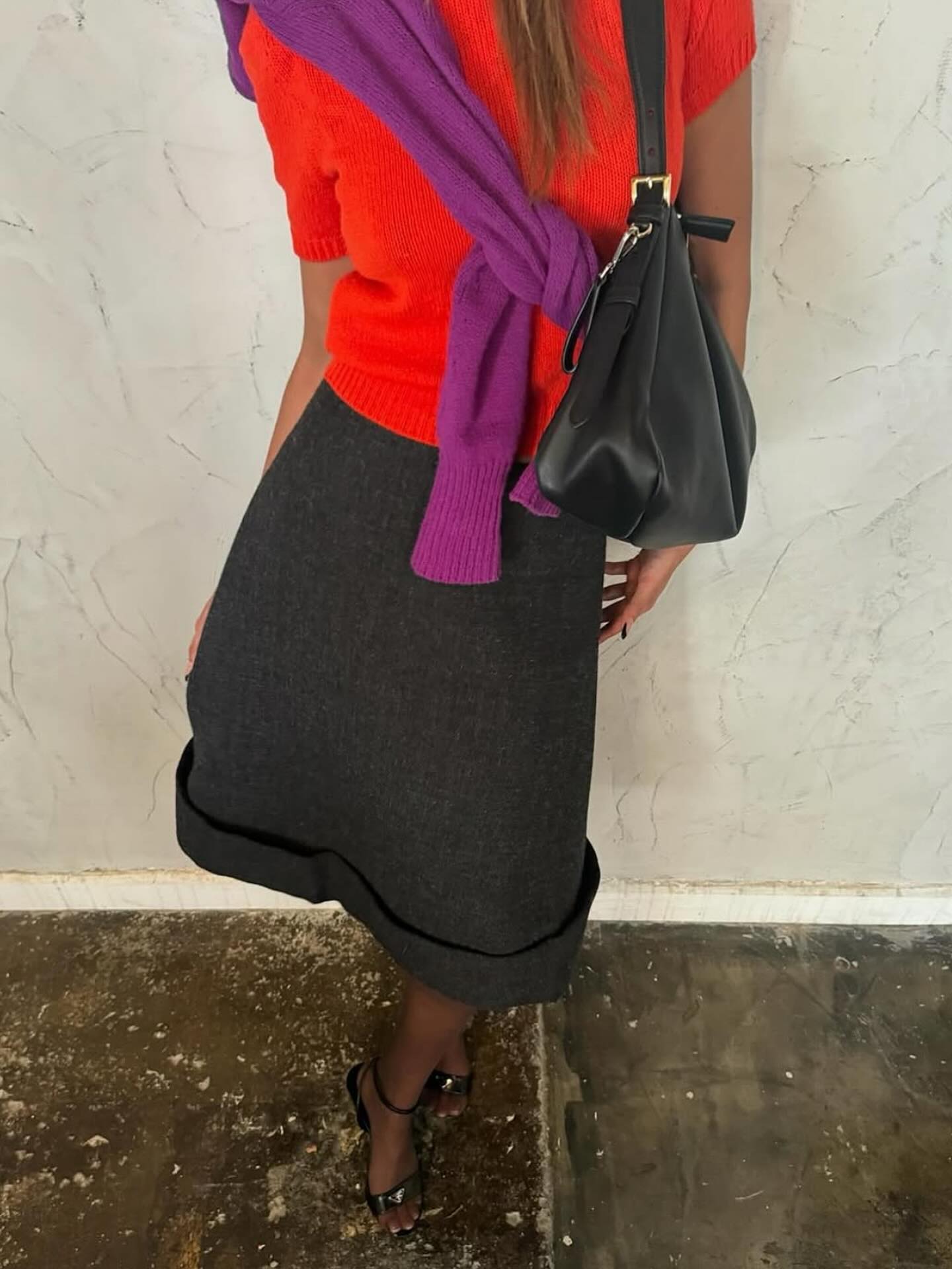 An image of @anaasaber wearing a red T-shirt with a purple knit and grey pencil skirt.