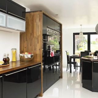 kitchen with black glossy shelves and walnut colour worktop