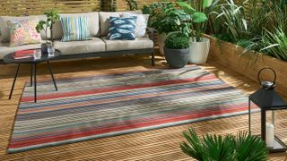 garden decking with sofa and outdoor rug