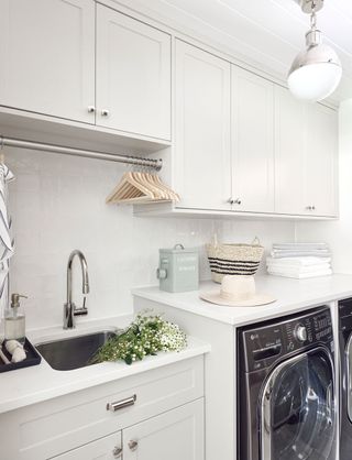 small laundry room ideas white room with hanging rail by Tiffany Leigh Design