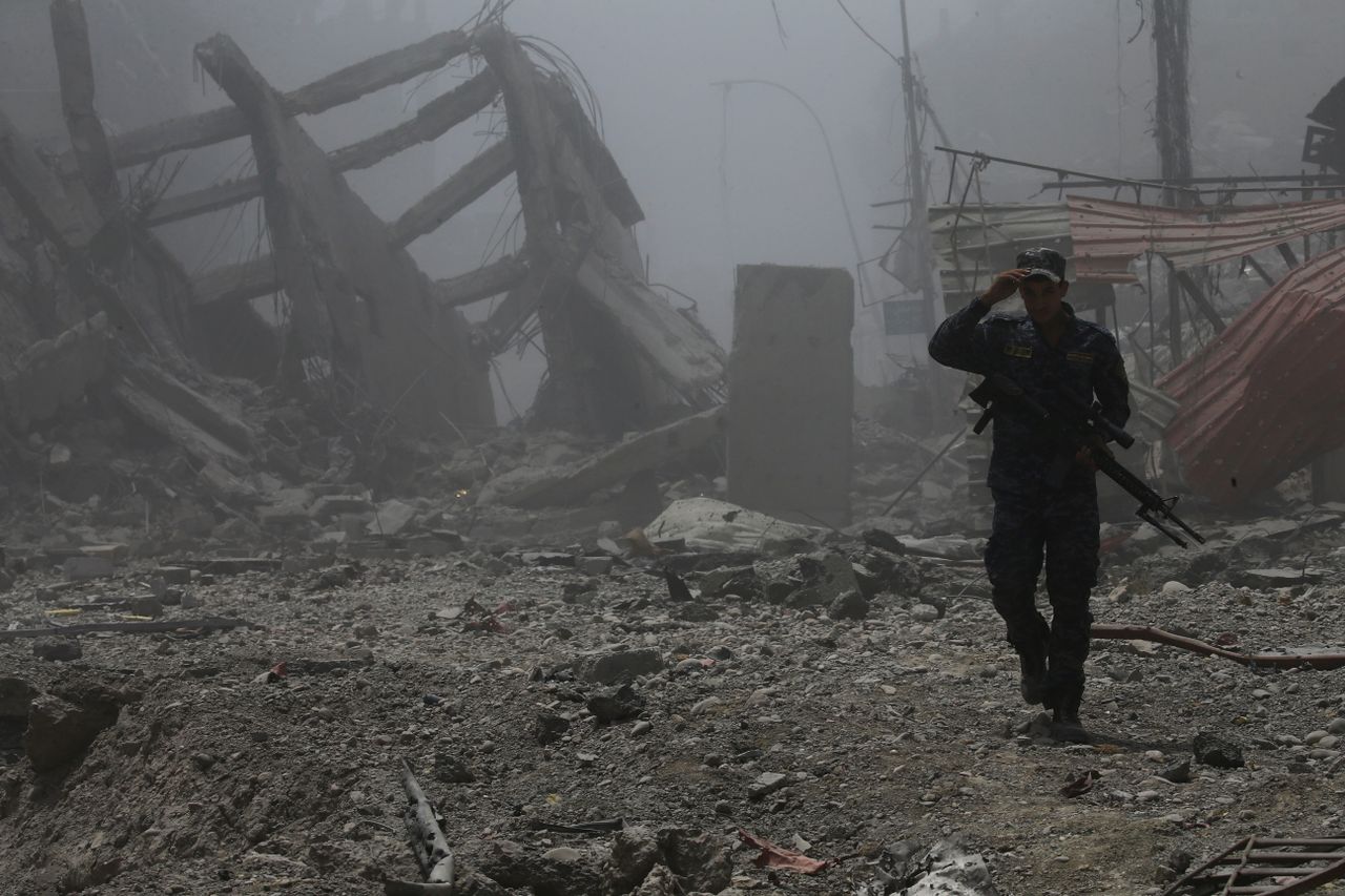 An Iraqi Federal police officer walks among the ruins in Mosul.