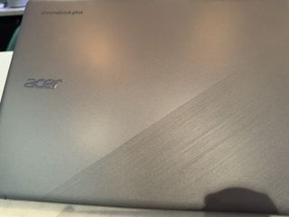 A silver Acer Chromebook Plus on a grey table