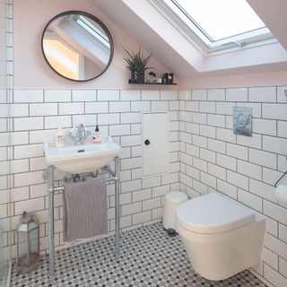 Bathroom with white subway tiles and black grout.