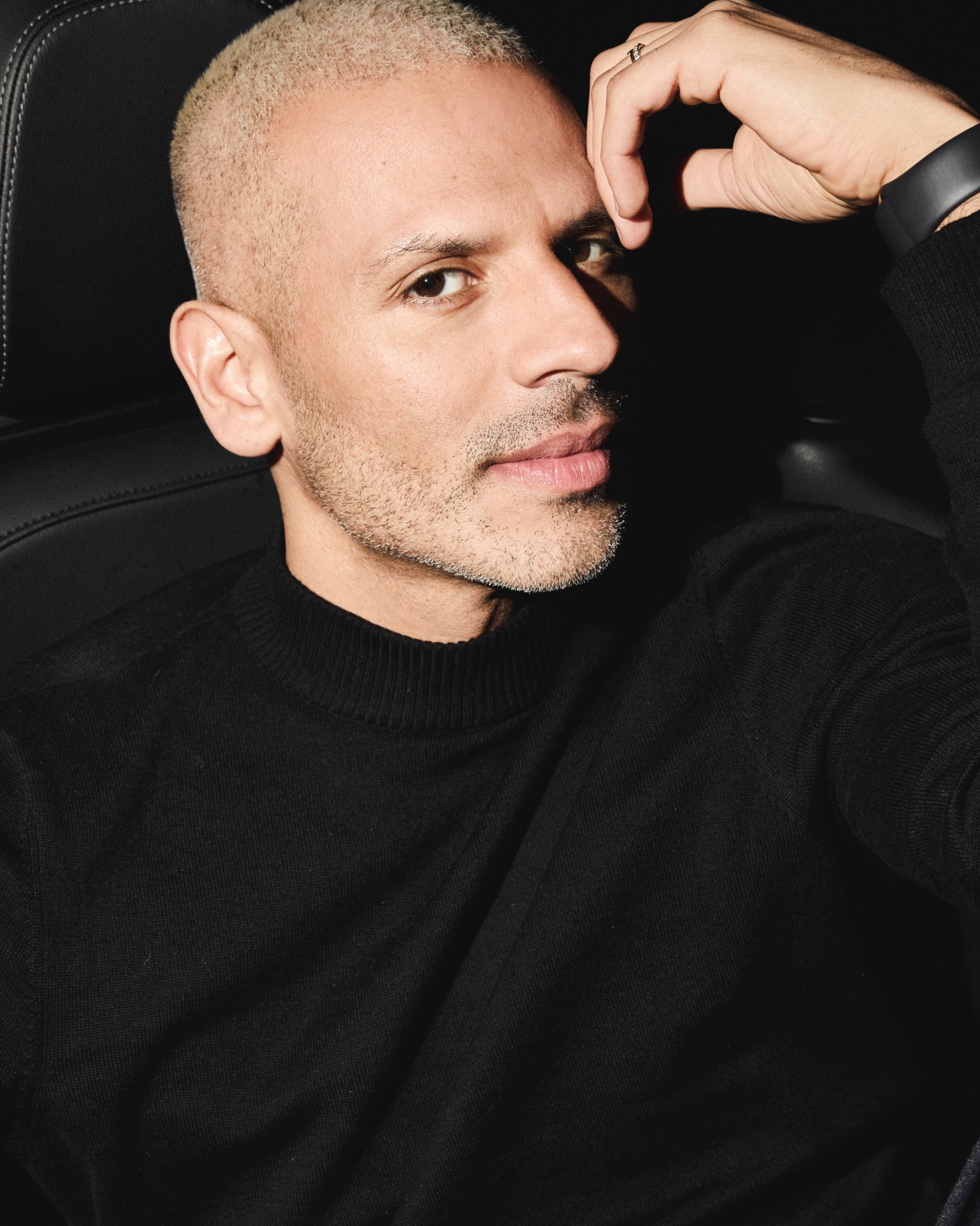 a man with buzzed blonde hair in a black turtleneck