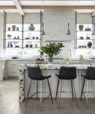 gray and wood kitchen with brass accents and black bar stools