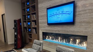 McIntosh house of sound TV over fireplace showing blue VU meter