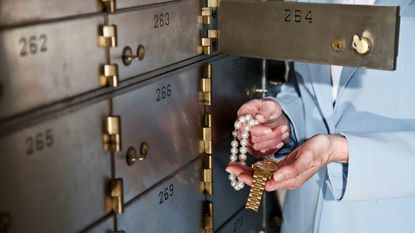 Woman putting jewelry in safety deposit box 
