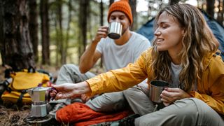 best hot drinks for camping: drinking coffee in camp