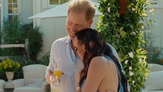 Prince Harry and Meghan Markle cuddling while holding drinks during an episode of With Love, Meghan.