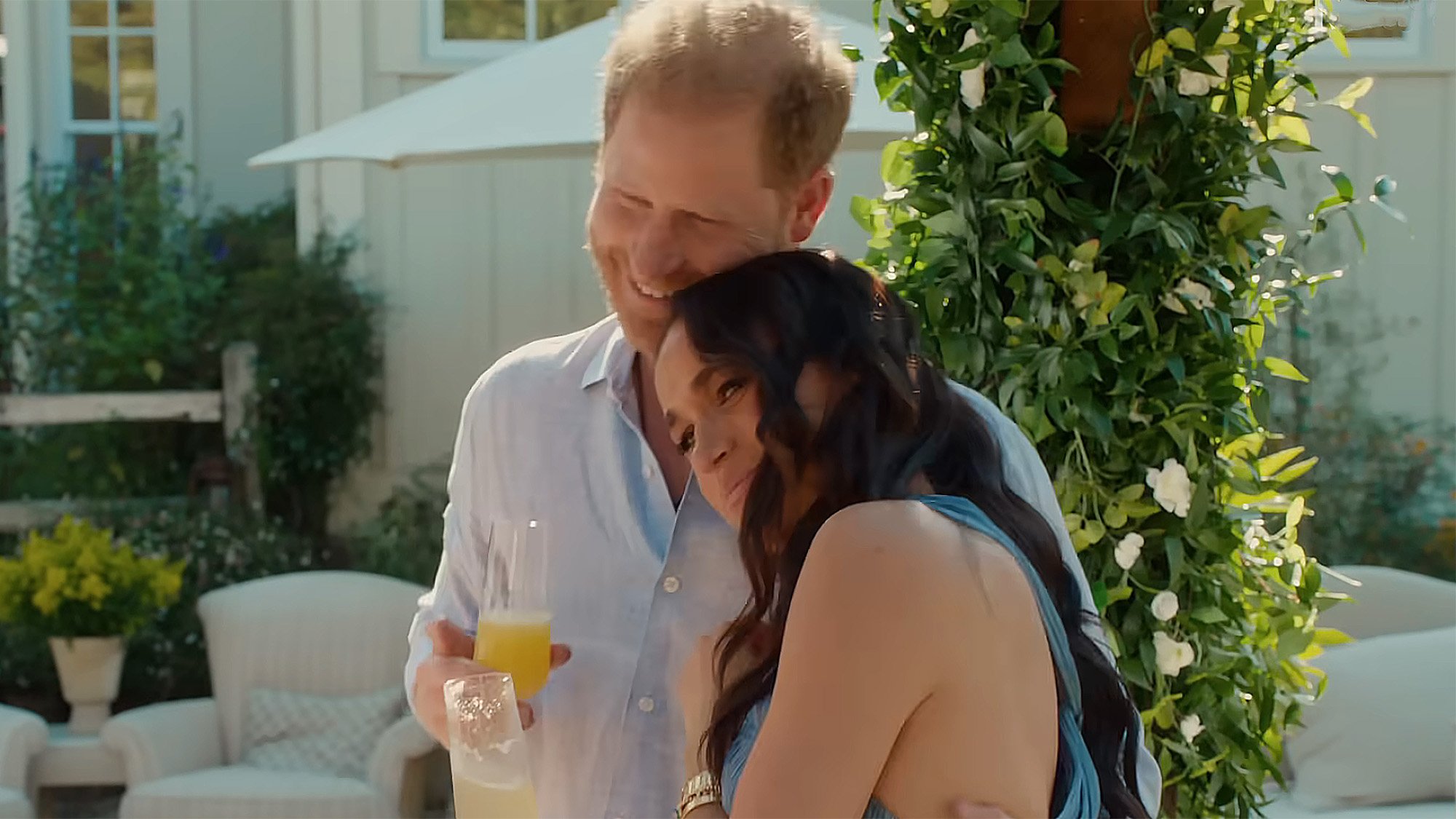 Prince Harry and Meghan Markle cuddling while holding drinks during an episode of With Love, Meghan.