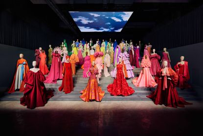 Mannequins on steps in Forever Valentino exhibition in colourful outfits