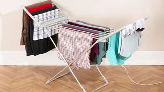 heated clothes airer with clothes drying on wooden floor