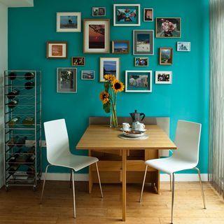 dining area with frames on wall and chairs with bottle racks