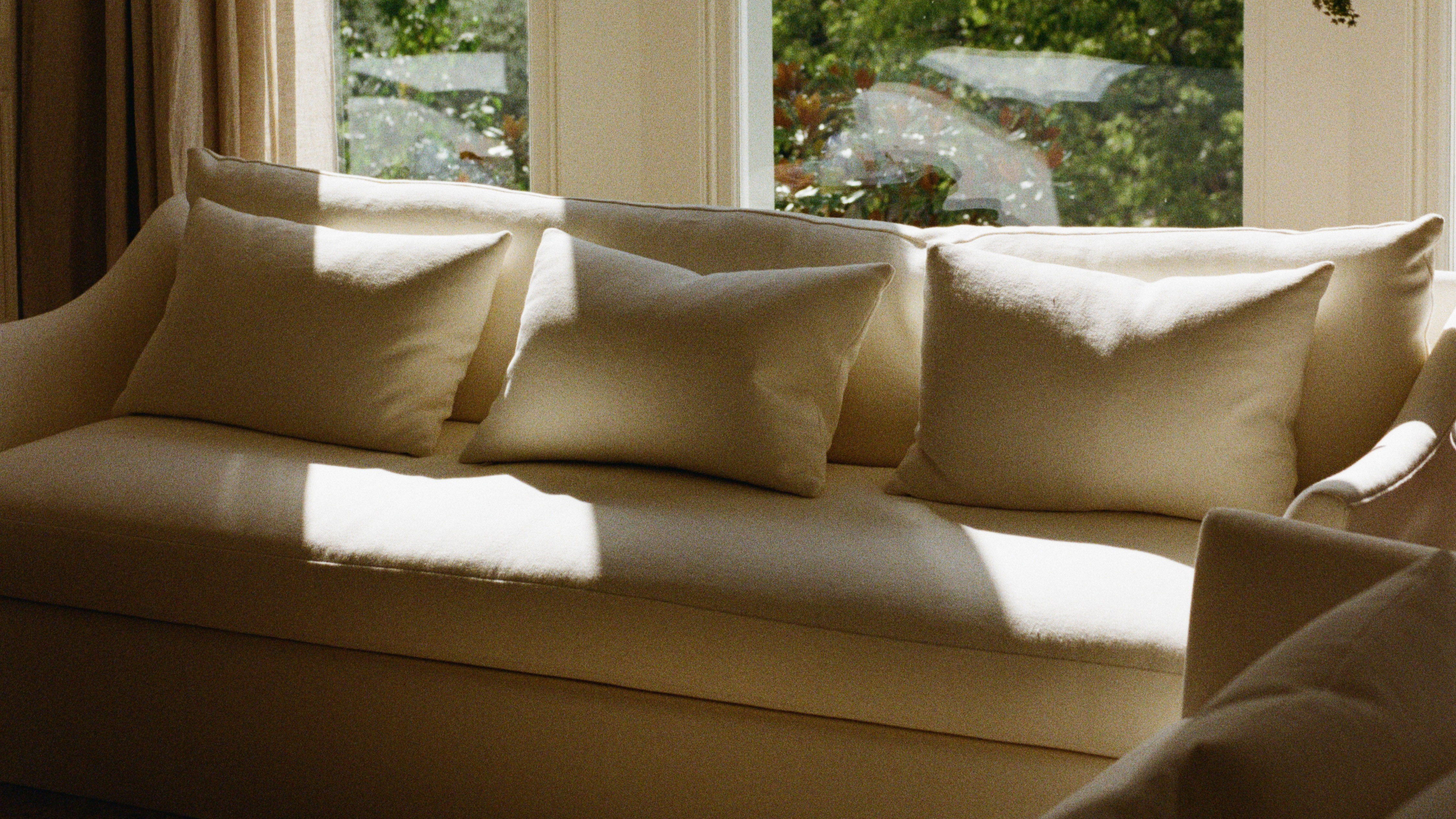 cream sofa in a window with sunlight shining across it