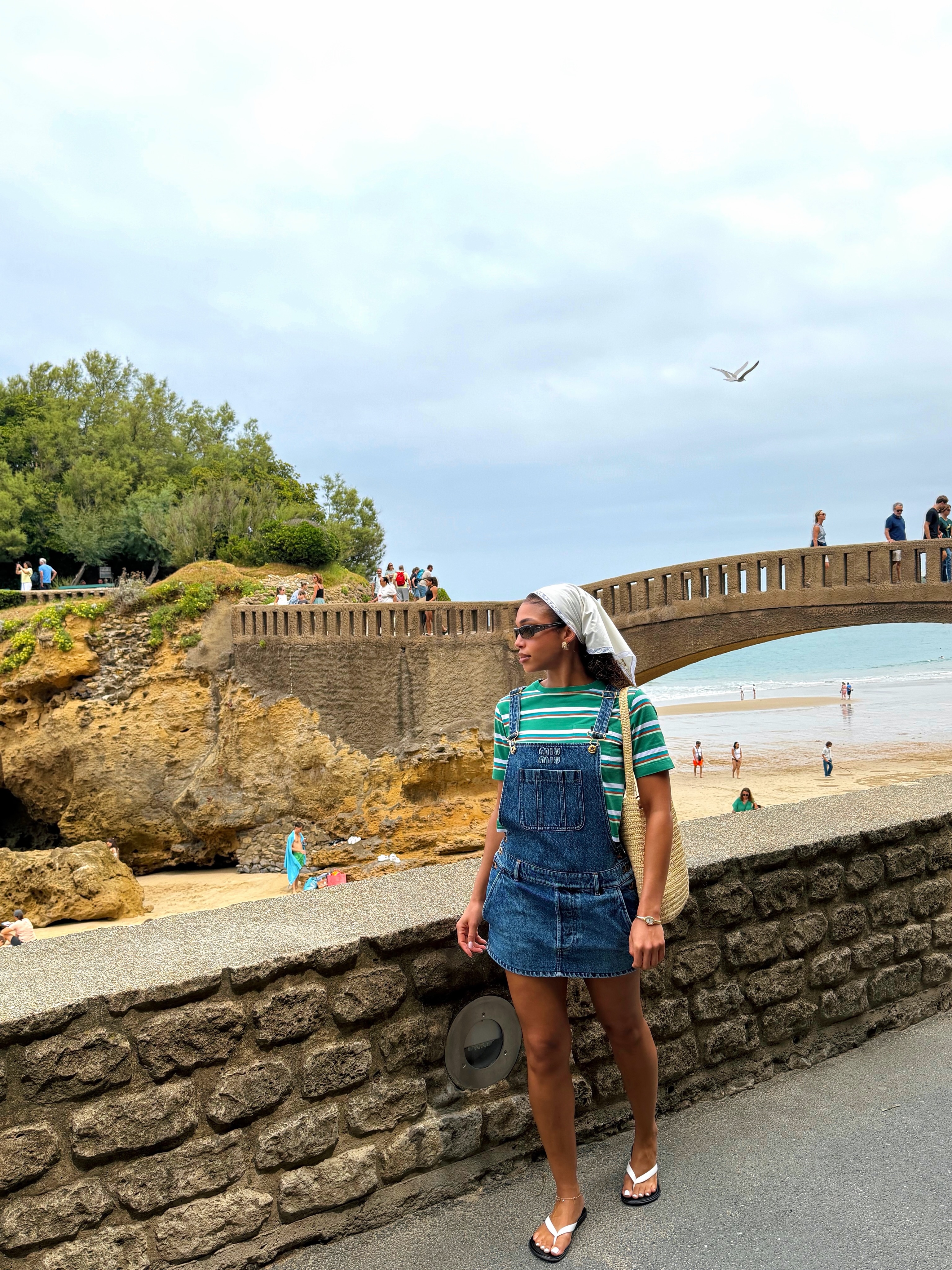 Lori Harvey styled the summer stripes trend with Miu Miu overalls and flip-flops on vacation