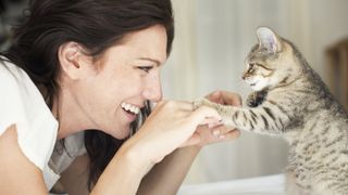 Lady interacting with cat, happy