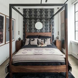 bedroom with white walls and wooden bed with cushions