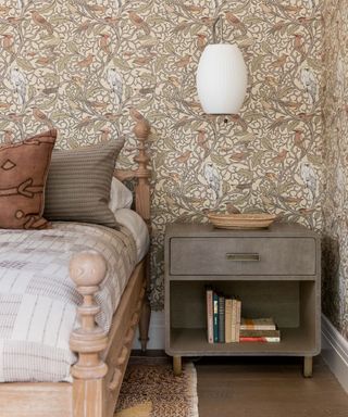 Small bedroom with close up bedside table and wallpaper in brown tones
