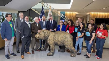 Governor Gavin Newsom signs legislation to strengthen worker protections with legislators, labor leaders, and workers