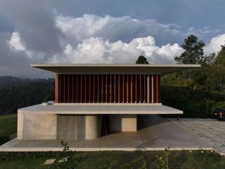 casa cuore in medellin sits in greenery enjoying long nature views that contrast its striking concrete and wood contemporary forms