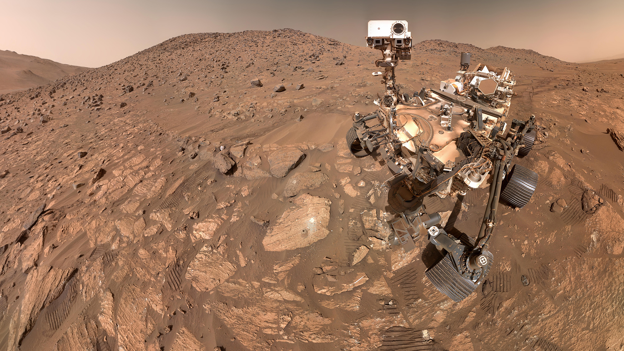 A close up of a rover on a reddish-brown planet. 
