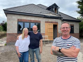 Mark Millar stood with couple in front of newly built bungalow.