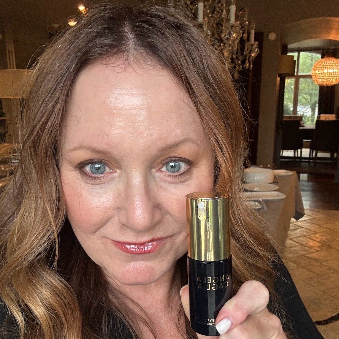 woman holding angela caglia cell forte eye creme