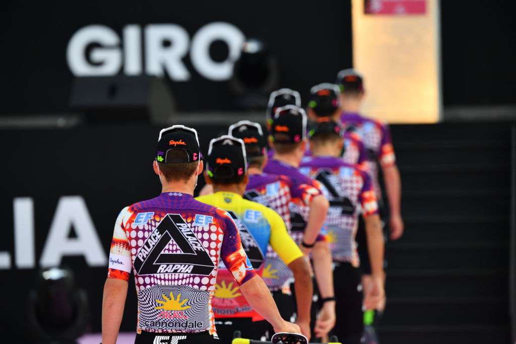 men line up for team presentation with bikes