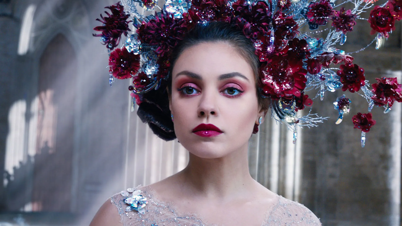 mila kunis in red makeup with a giant flower crown in a still from the movie jupiter ascending