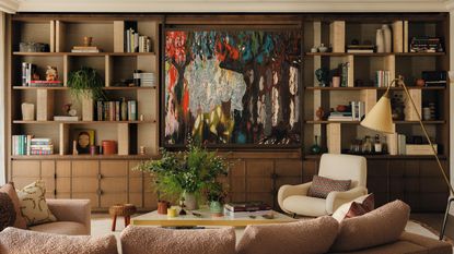 a layered living with a large wooden media wall and abstract artwork hiding the TV