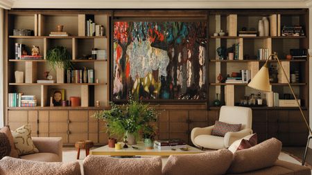 a layered living with a large wooden media wall and abstract artwork hiding the TV
