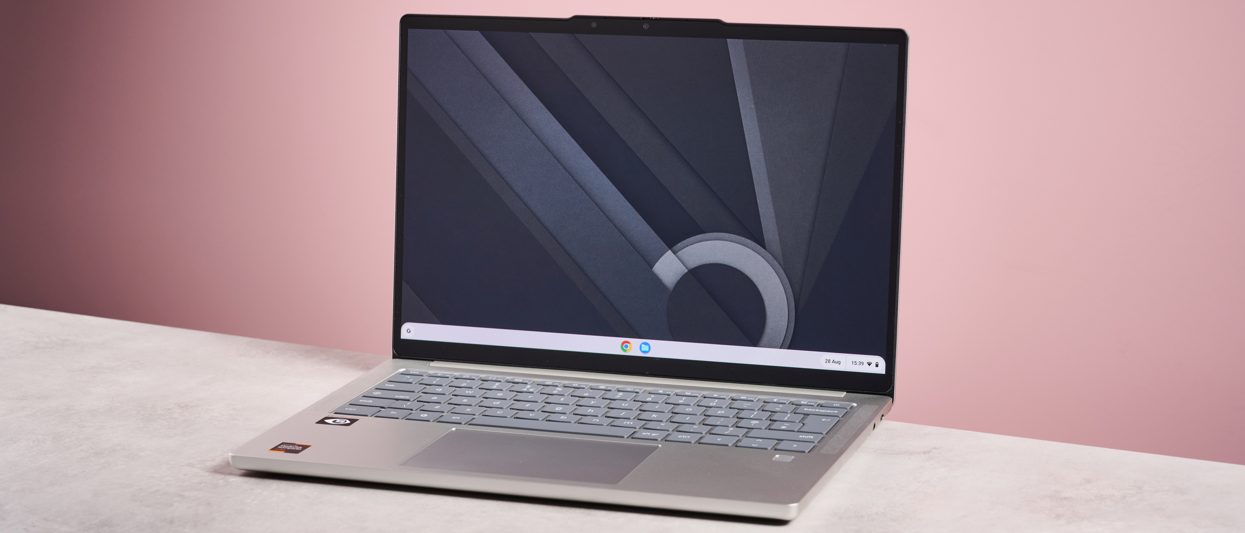 Lenovo Chromebook Plus 14-inch open on desk with pink background