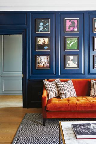 Living room with blue walls and an orange sofa