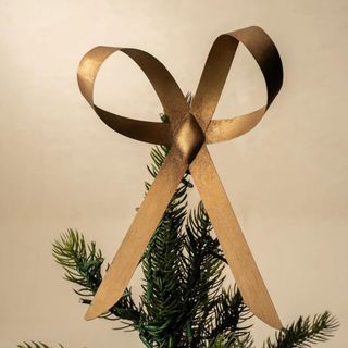 Brass Bow Tree Topper against a cream background.