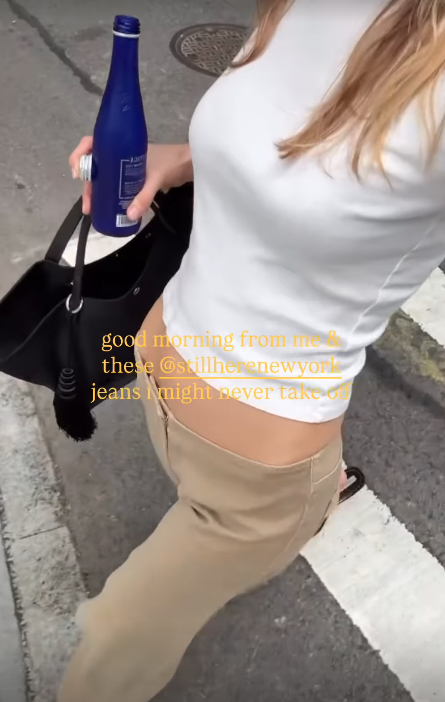 Courtney Grow wearing a white T-shirt and Still Here's sold out Sport Jeans in the color pear.